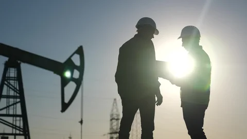 Industrial professionals reviewing documentation at an oil field site